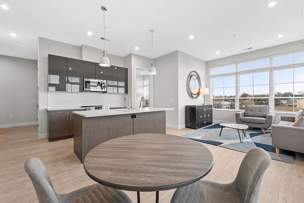 A modern kitchen with a dining table and chairs.