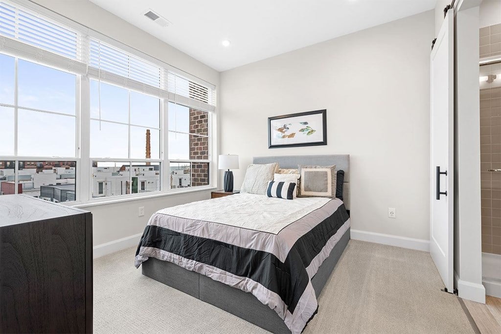A bedroom with a large bed and a view of the city.