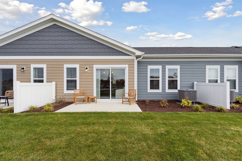 A house with a grey roof and a white fence.