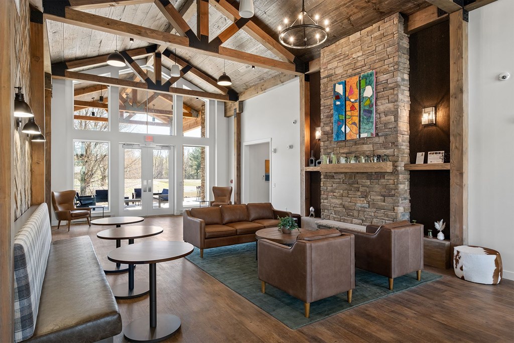 A living room with a stone fireplace and a large window.