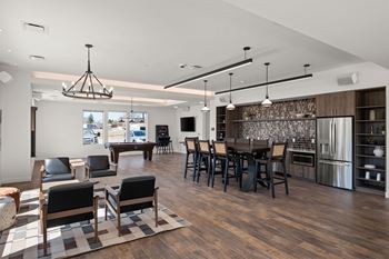 A modern kitchen with dark wood floors and a large island.