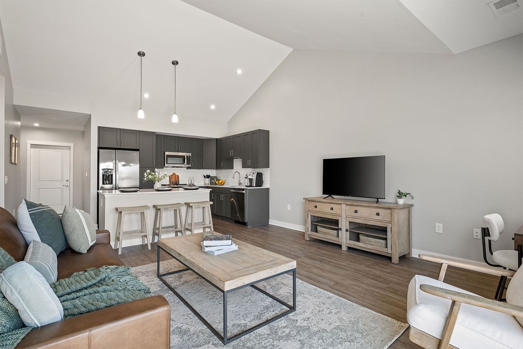 A modern living room with a brown leather couch and a wooden coffee table.