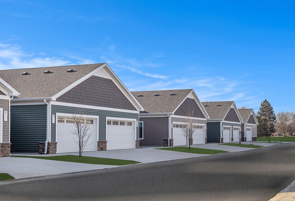 A row of houses with garages and driveways.
