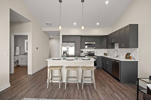 A modern kitchen with a center island and bar stools.