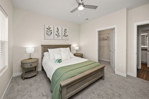 A bedroom with a bed, nightstand, and a ceiling fan.
