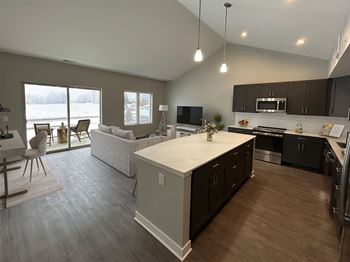 an open kitchen and living room with a view of a lake