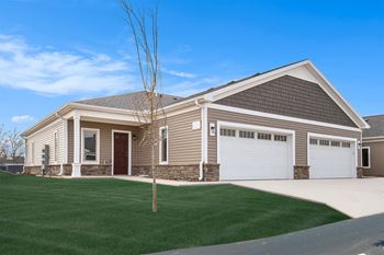 a house with a driveway and lawn in front of it