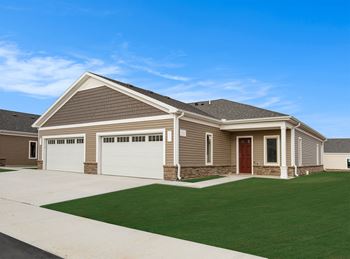 a house with a driveway and lawn in front of it