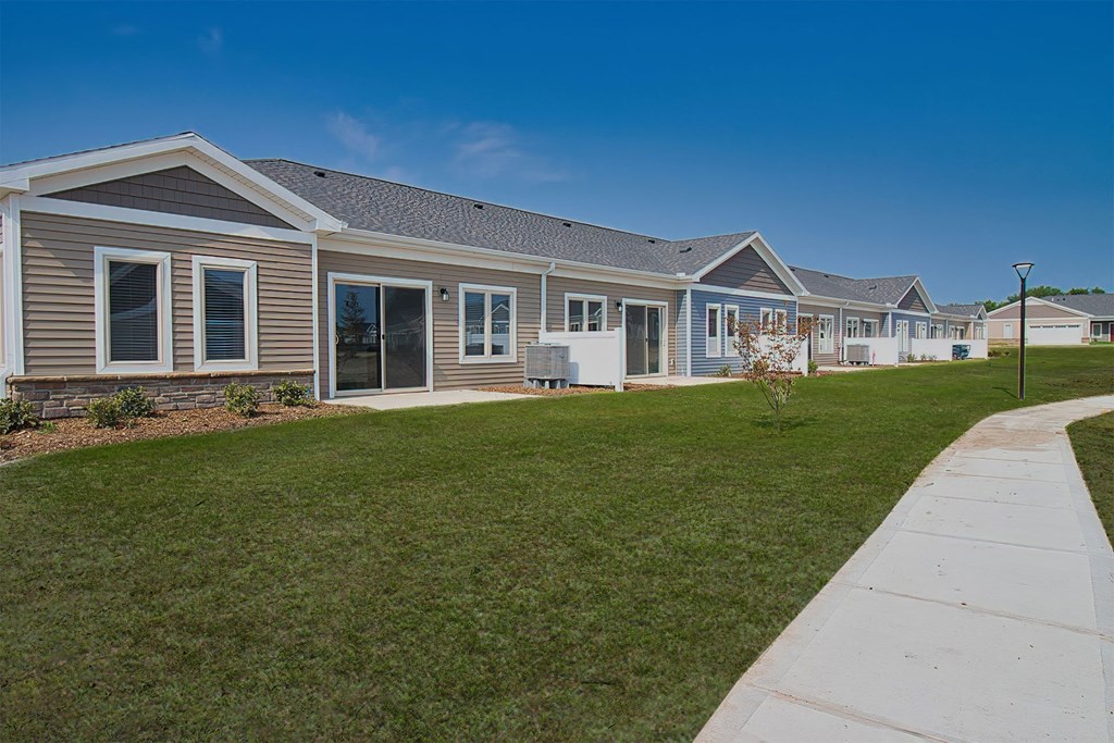 a row of homes with a lawn and sidewalk in front of them
