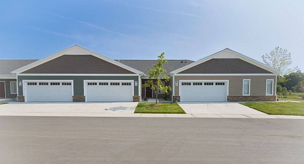 a house with two garage doors in front of a driveway