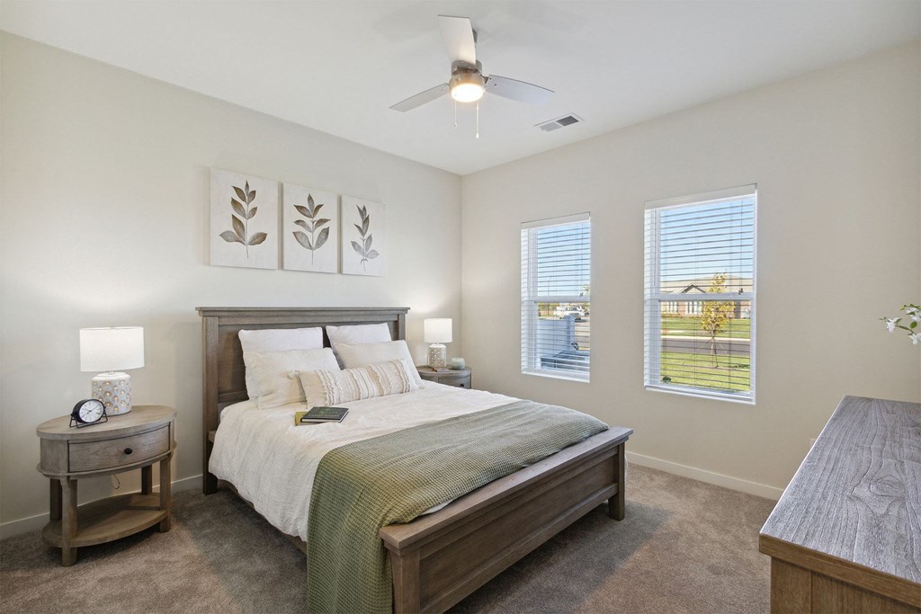 a bedroom with a bed and two windows
