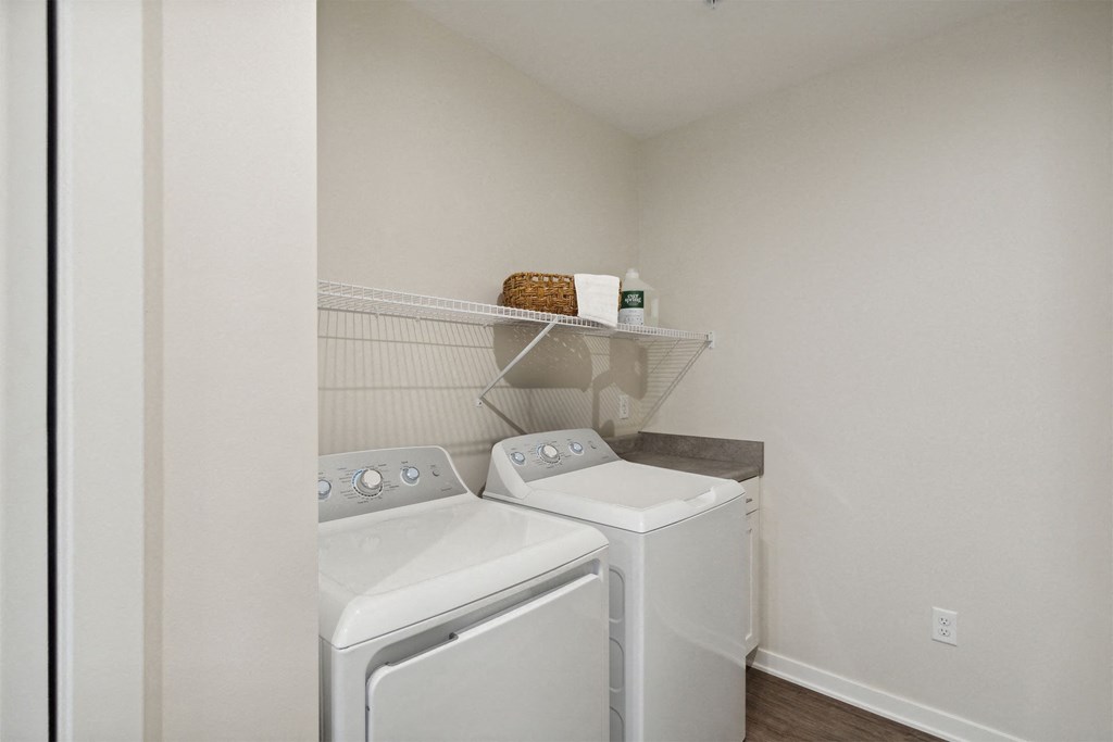 an empty laundry room with two washes and a dryer