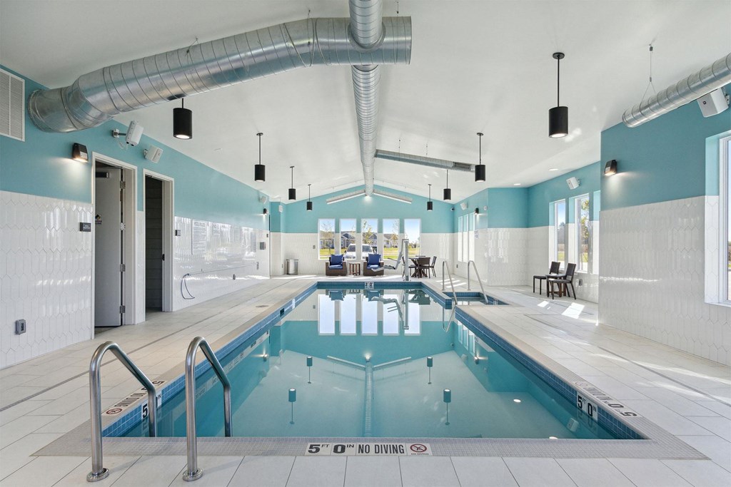 a swimming pool in a room with blue and white walls and a ladder over it