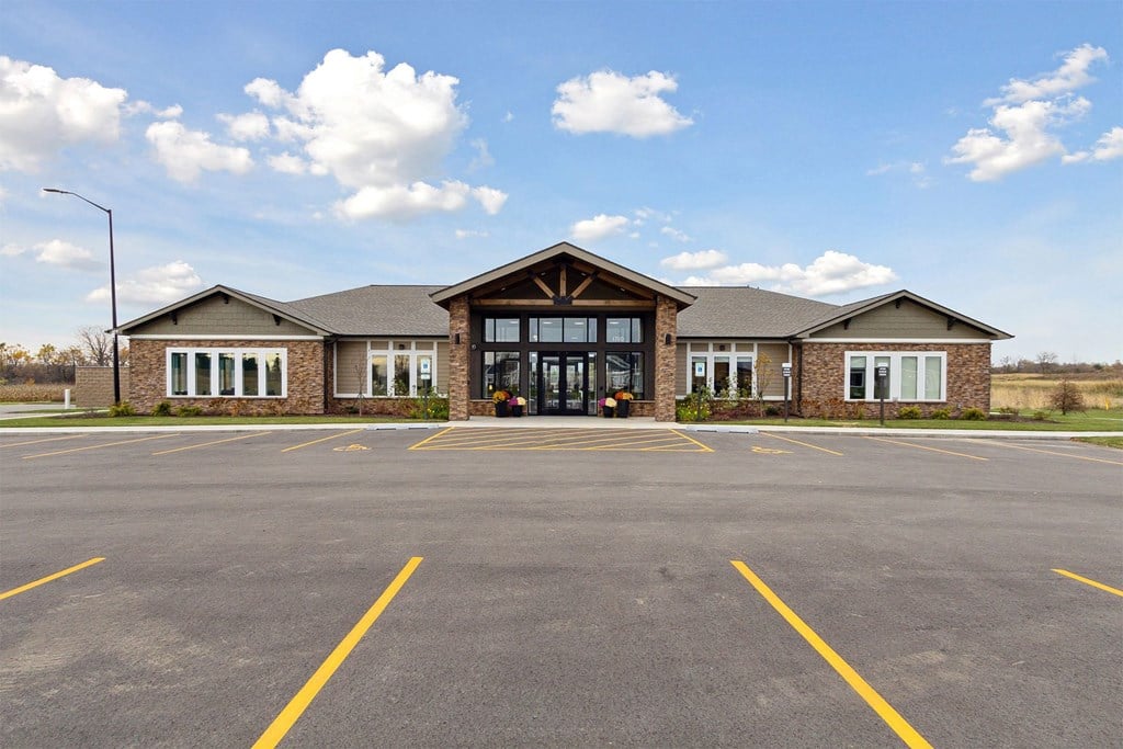 the exterior of a brick building with a parking lot