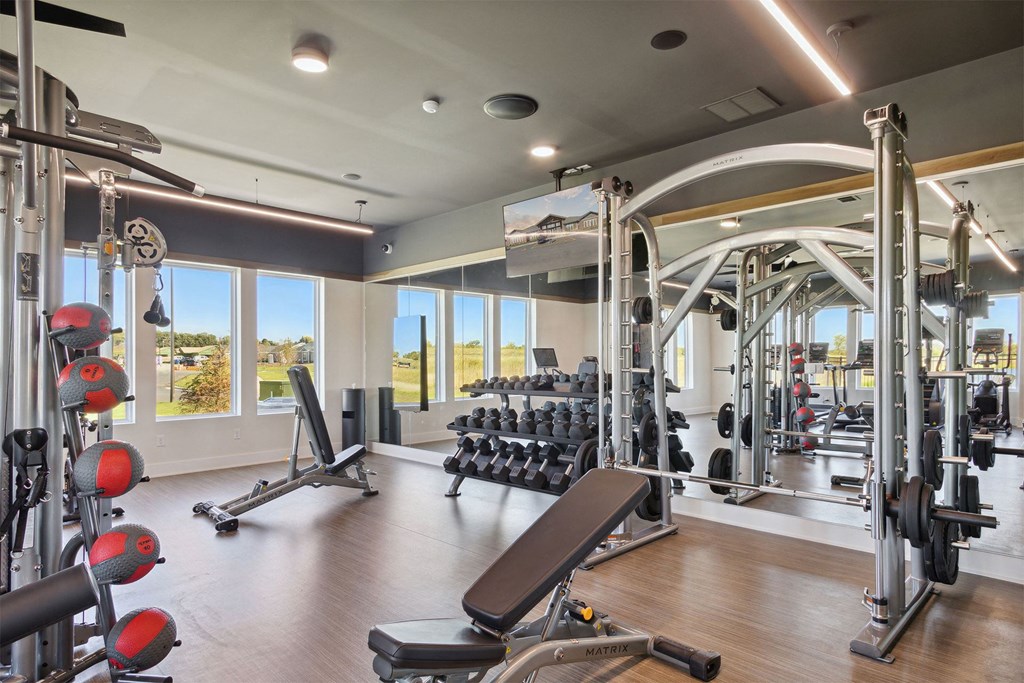 a gym with weights and other exercise equipment and windows