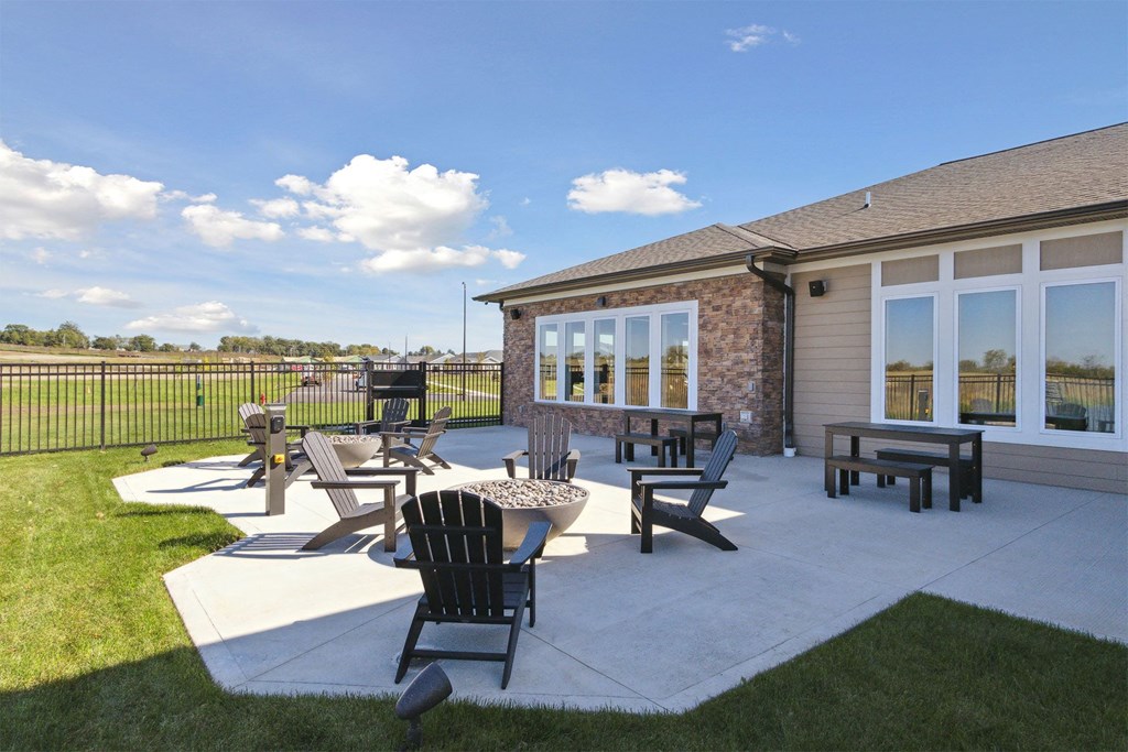 a patio with tables and chairs in front of a building