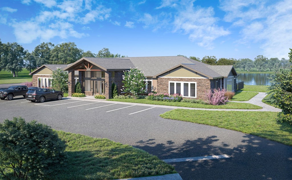 parking lot and leasing office building with lake behind it