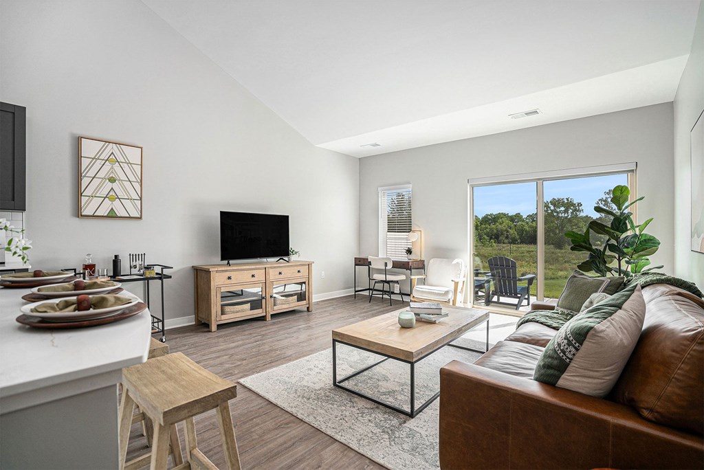 A modern living room with a brown leather couch and a wooden coffee table.