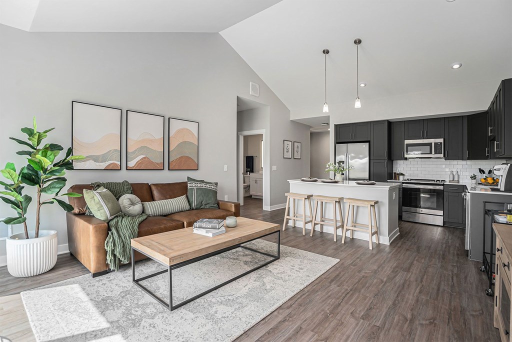 A modern living room with a brown leather couch and a wooden coffee table.