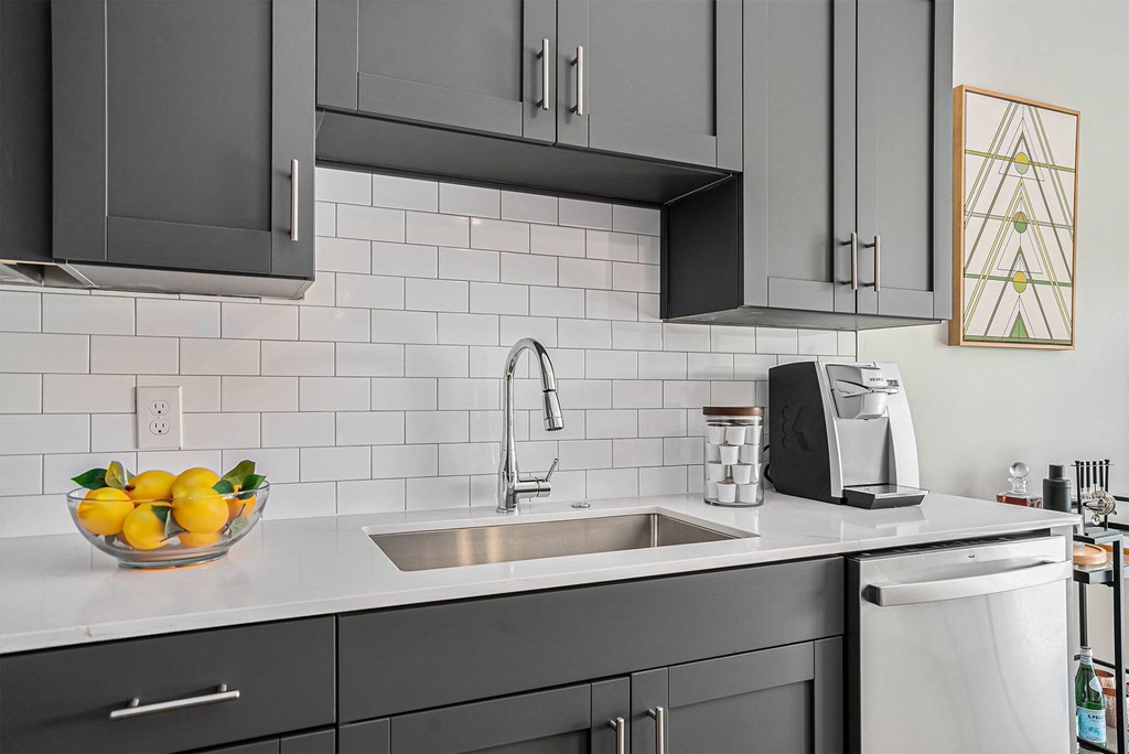A modern kitchen with a bowl of lemons on the counter.