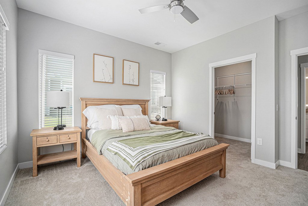 A bedroom with a bed, nightstand, and window.