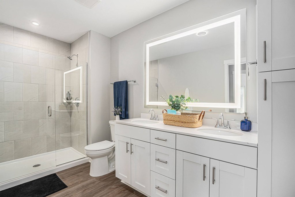 A white bathroom with a toilet, sink, and mirror.