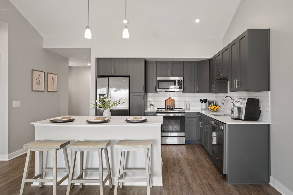 a kitchen with a large island with stools