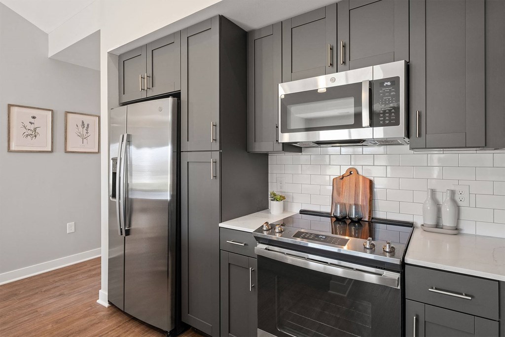 a kitchen with stainless steel appliances and black cabinets