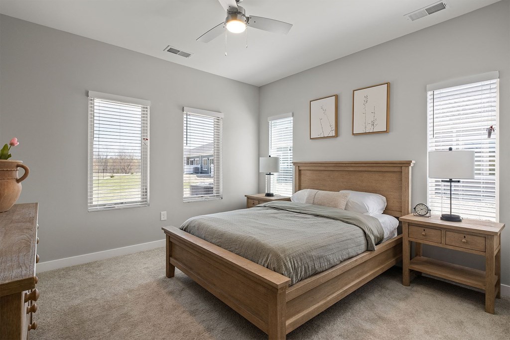 a bedroom with a bed and three windows