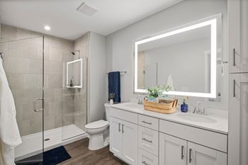 a white bathroom with a large mirror and a shower