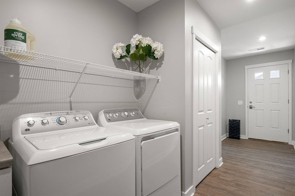 a washer and dryer in a laundry room with a white door