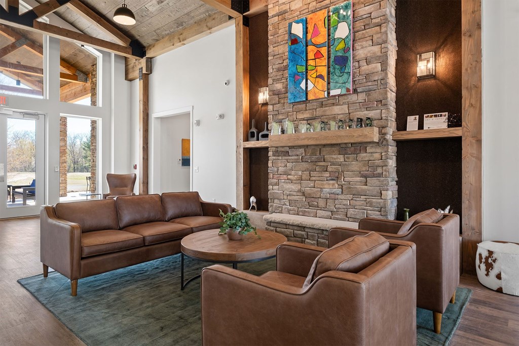 a living room with leather furniture and a stone fireplace