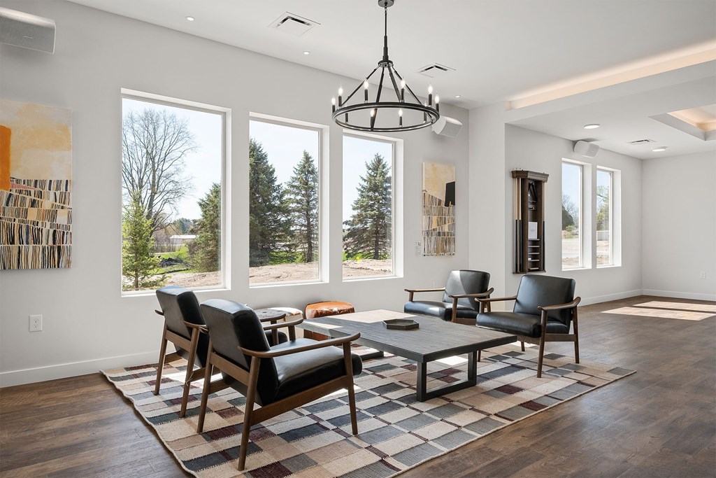a living room with a table and chairs and large windows
