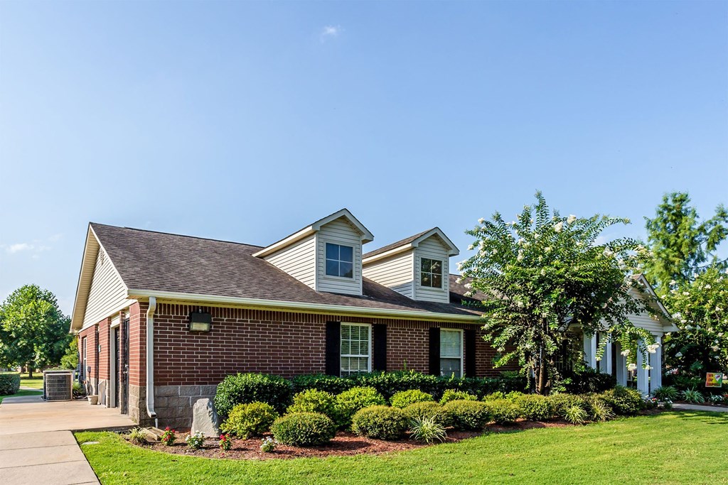 A house with a well-maintained lawn and a clear blue sky above.