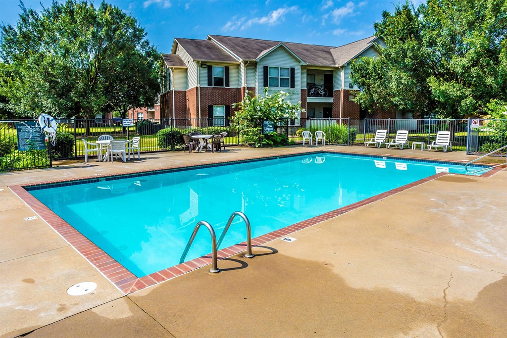 A swimming pool in front of a house.