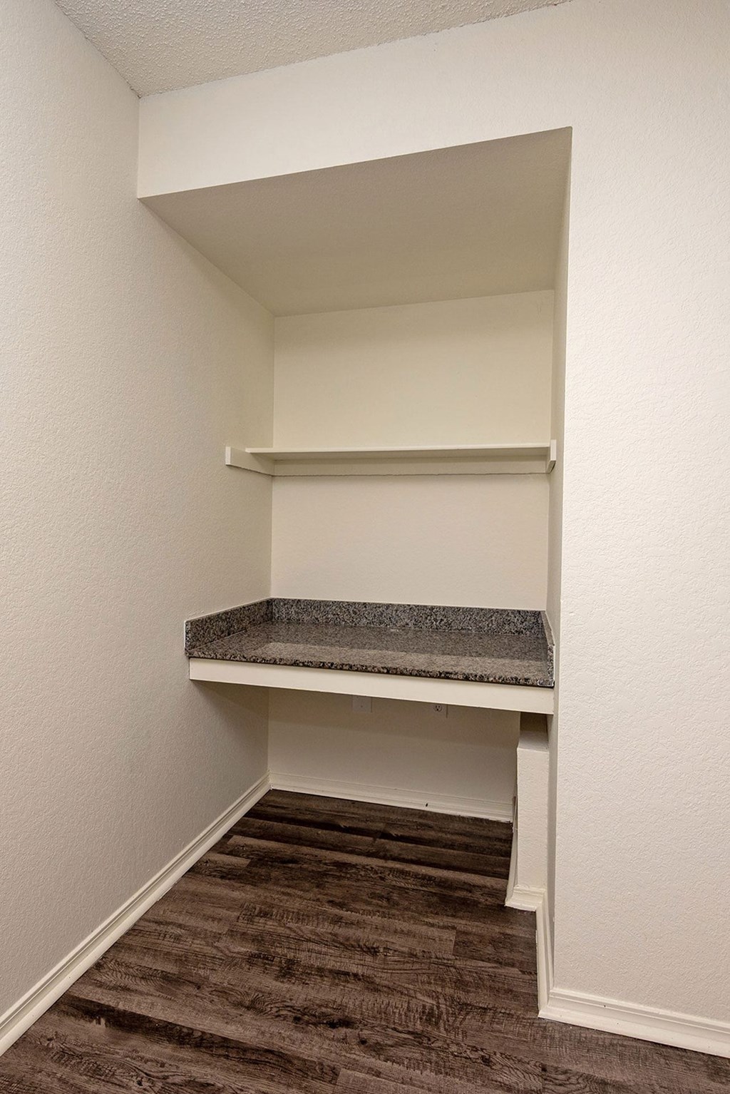 A small room with a bed and a carpeted floor.