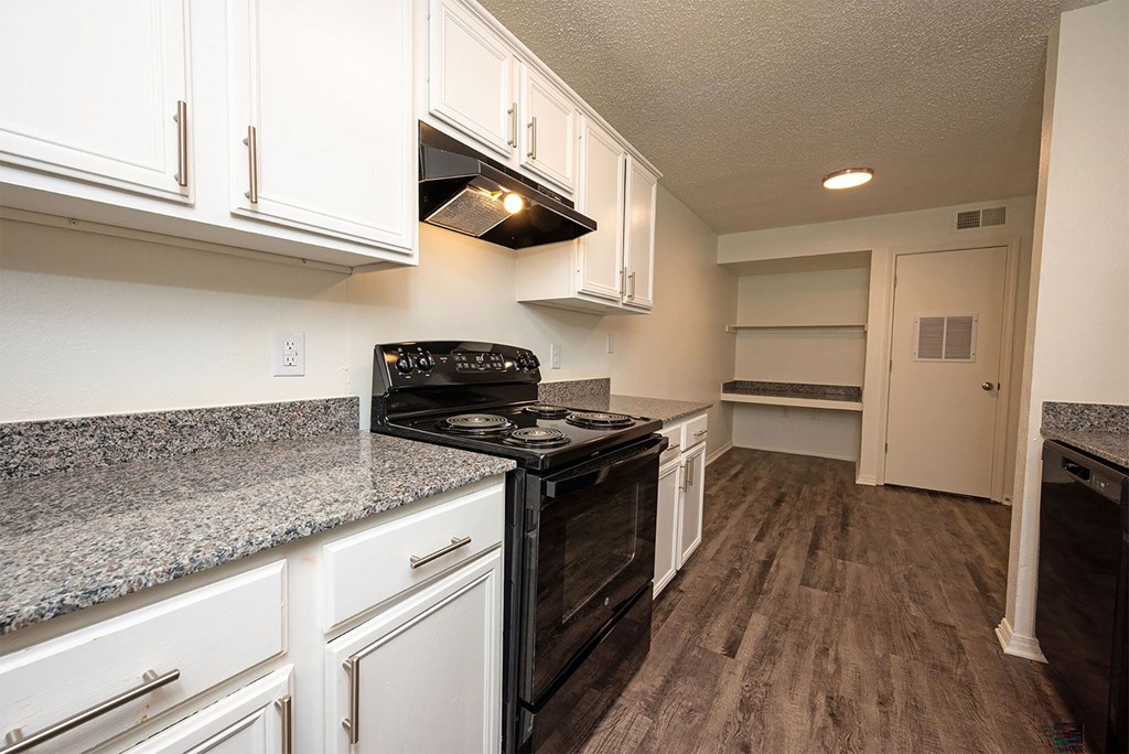 A kitchen with black appliances and white cabinets.