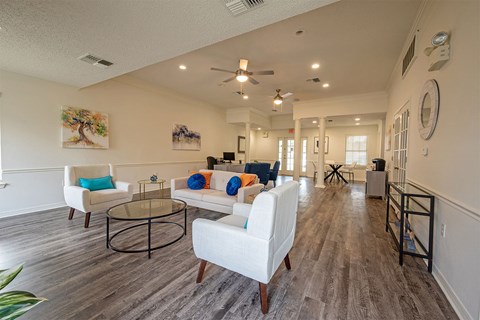 A living room with a white couch and a glass coffee table.