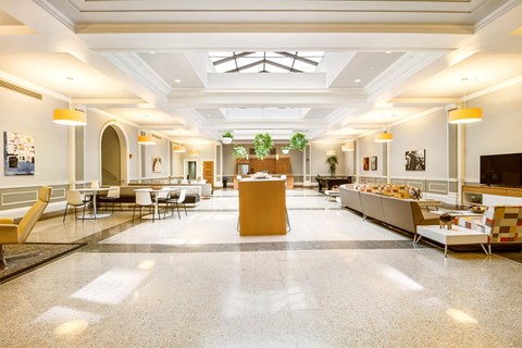 A spacious cafeteria with tables and chairs and a counter.