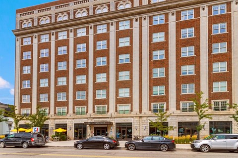 A large red brick building with a parking lot in front.