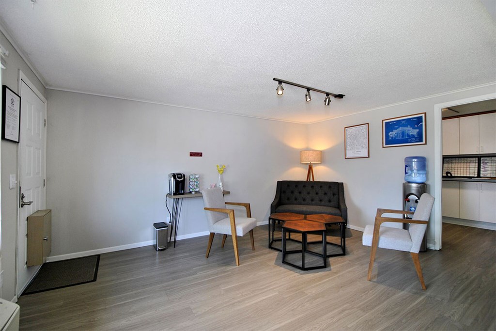 A living room with a sofa, two chairs, and a coffee table.