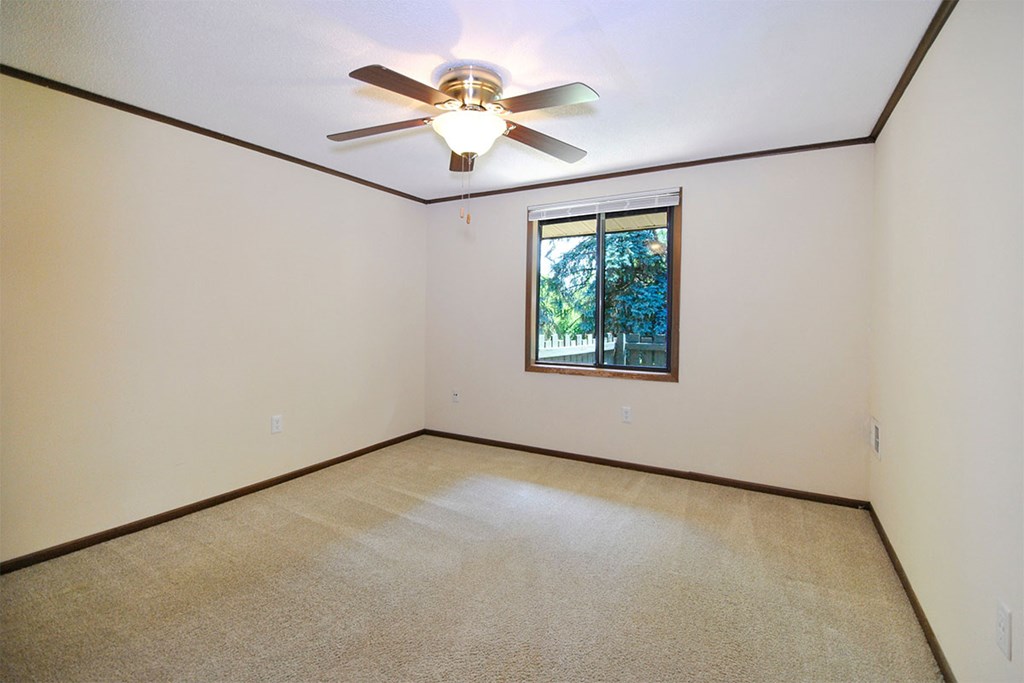 A room with a ceiling fan and a window.