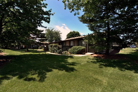 A house with a lawn and trees in front of it.