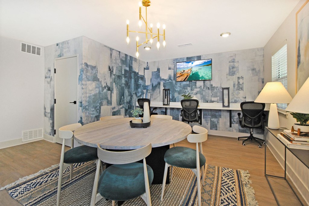 a dining room with a table and chairs and a tv on the wall