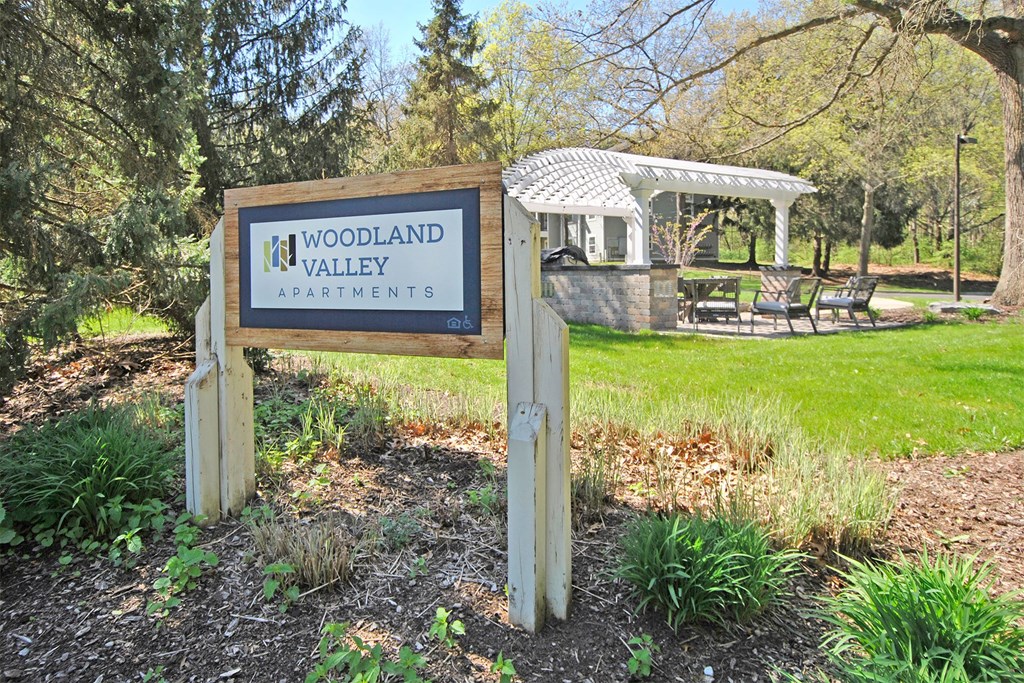 a park with a sign for woodland valley apartments and a gazebo