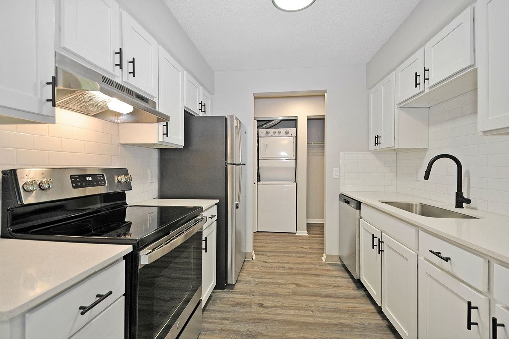 a kitchen with white cabinets and black appliances