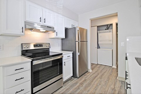 a renovated kitchen with white cabinets and stainless steel appliances