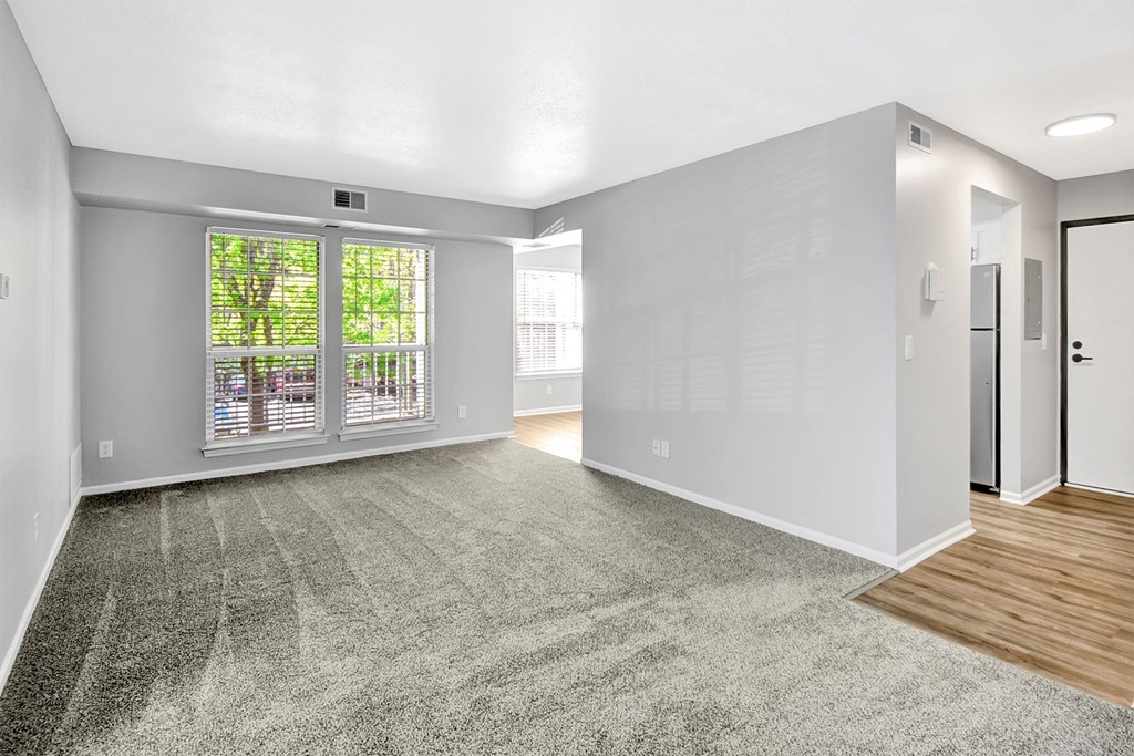 an empty living room with a door to a balcony