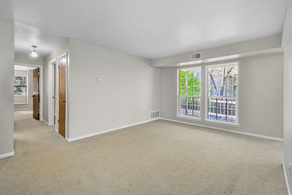 the living room of an empty house with a large window