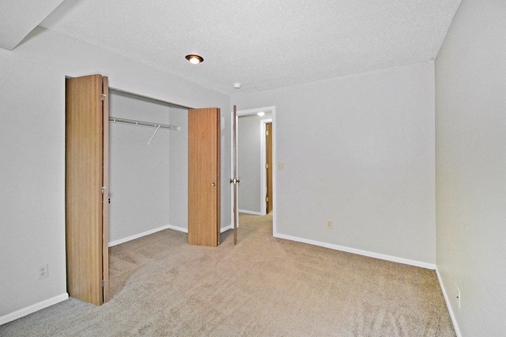 an empty room with a closet and a door to a bathroom